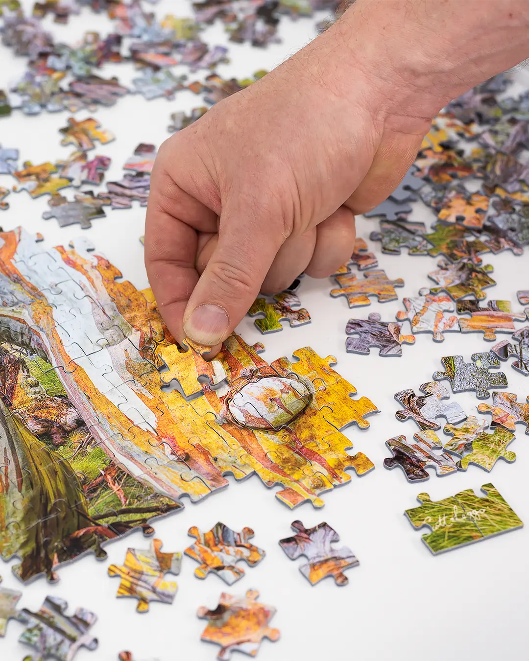 hand placing jigsaw puzzle piece into place.