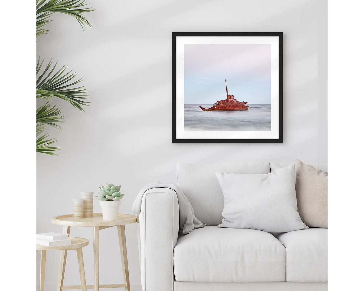 Abandoned. Wall art print of MV Sygna, Stockton Beach, Newcastle, framed in a black frame and hung above a lounge room couch. 