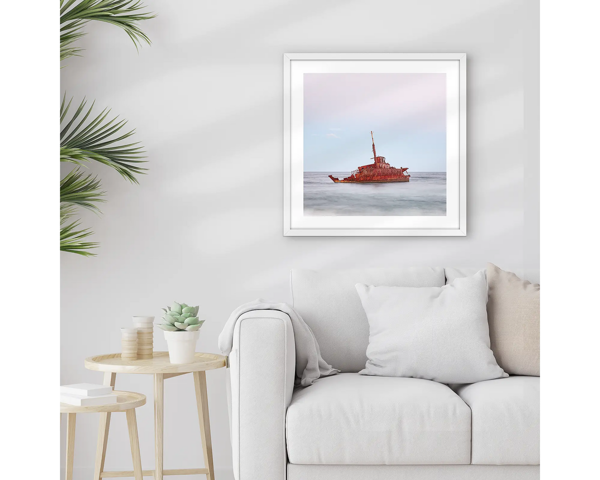 Abandoned. Wall art print of MV Sygna, Stockton Beach, Newcastle, framed in a whtie frame and hung above a lounge room couch. 