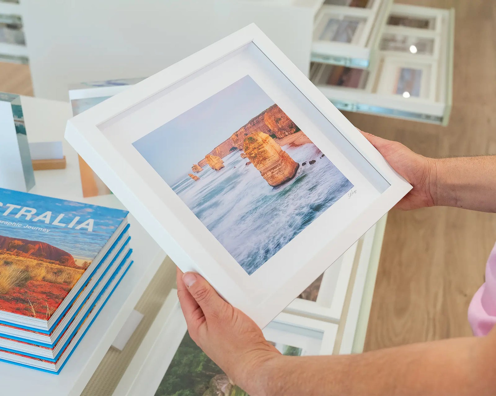 Framed photograph of Twelve Apostles protruding out of a foamy ocean. 