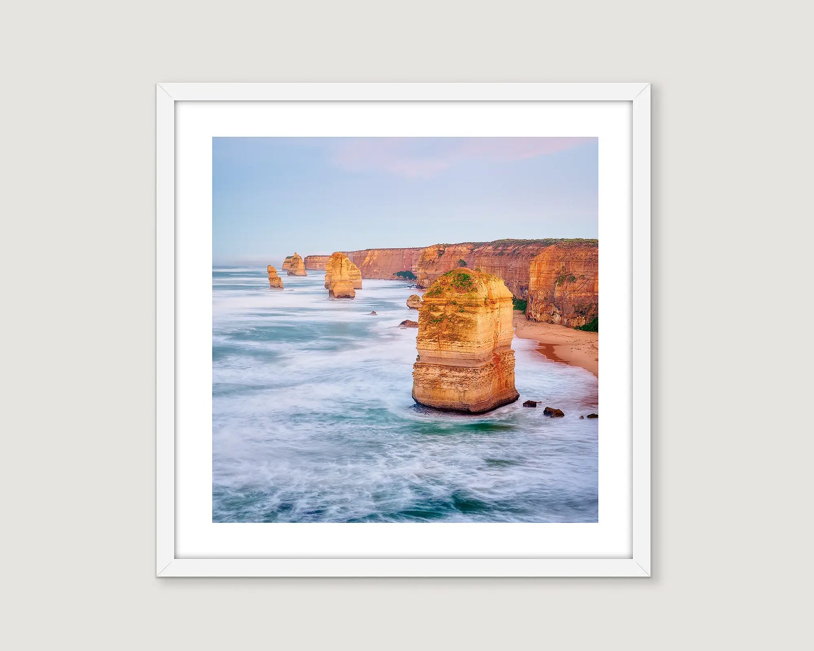 Framed photograph of Twelve Apostles protruding out of a foamy ocean. 