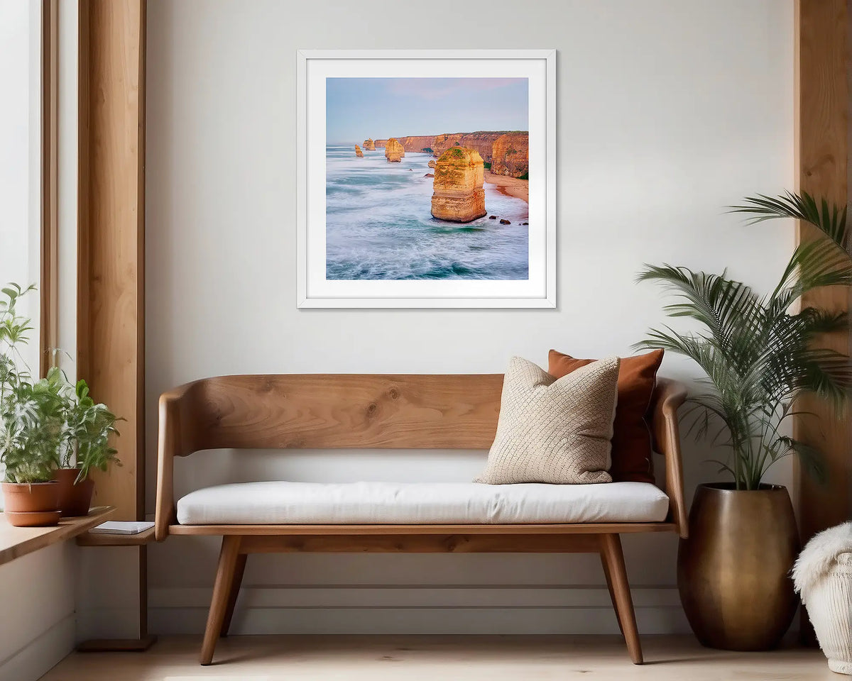 Against the Tide. White framed wall art print of the Twelve Apostles hung in a scandi-themed waiting area. 