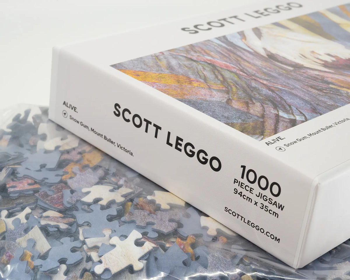 Alive. 1000 piece jigsaw puzzle of colourful snow gum bark patterns, open box showing unique puzzle pieces.