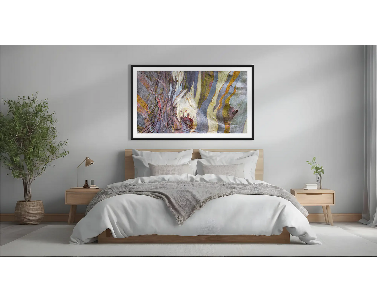 Alive. Abstract snow gum wall art print with a black frame, hung above a bed. 