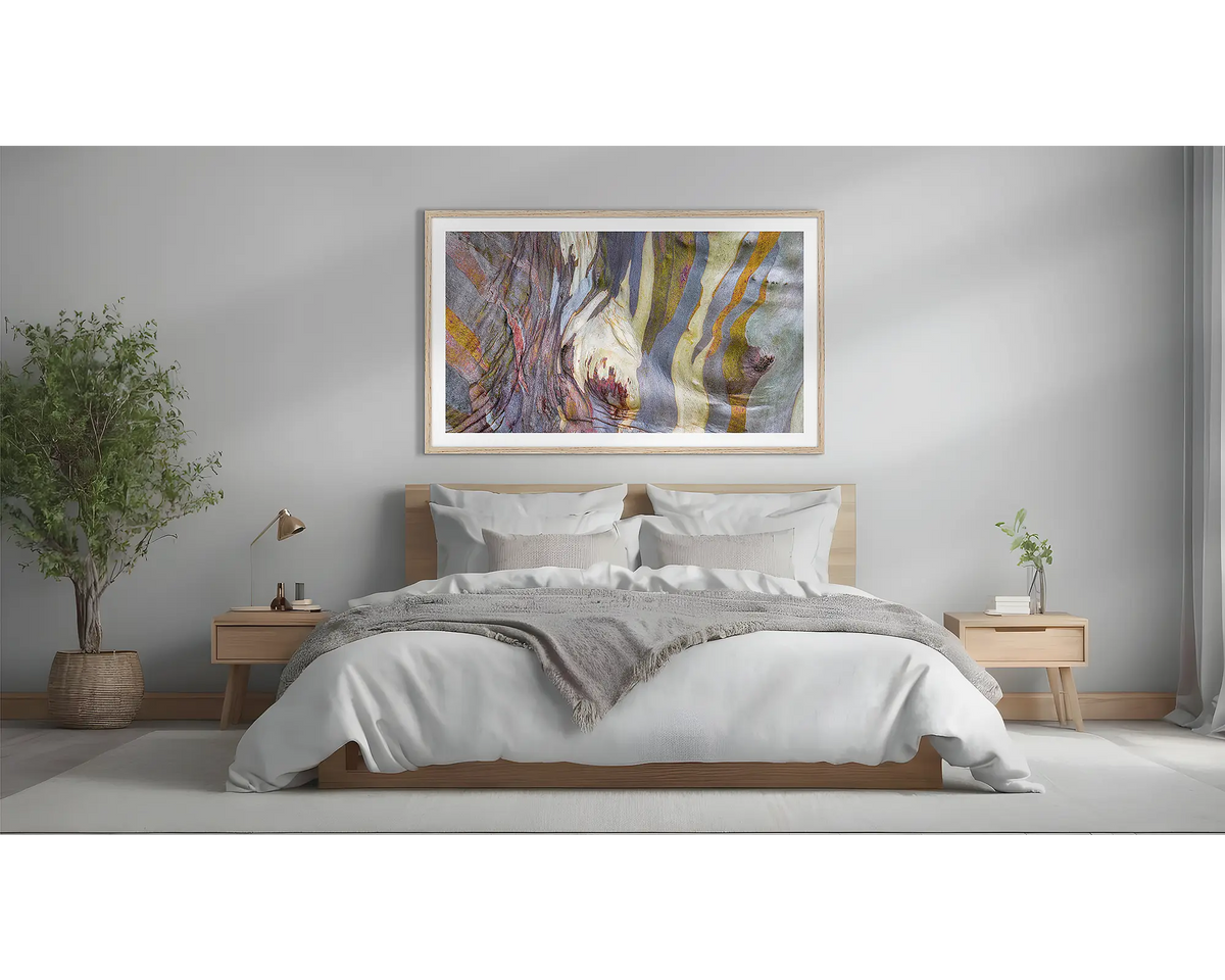 Alive. Abstract snow gum wall art print with a timber frame, hung above a bed. 