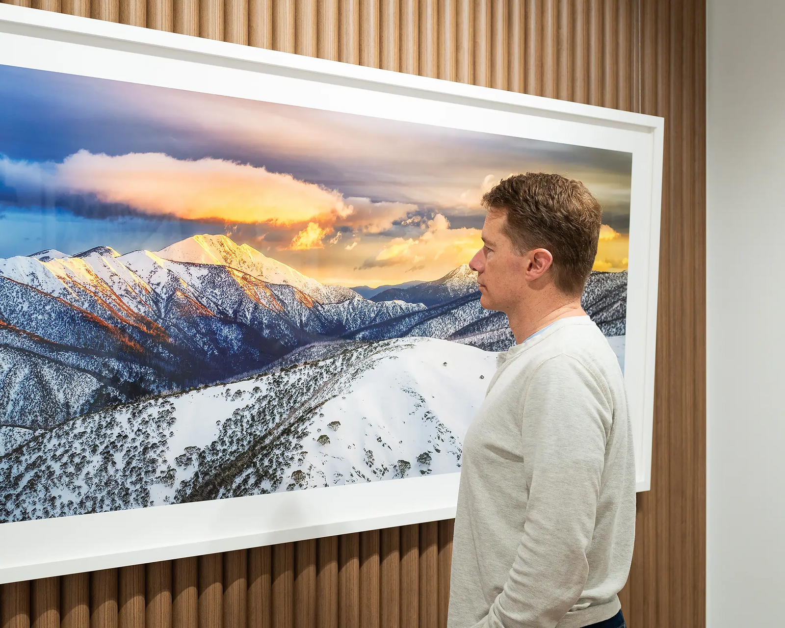 Framed photographic print of rising sun casting gold over the snowy peaks of Mount Feathertop. 