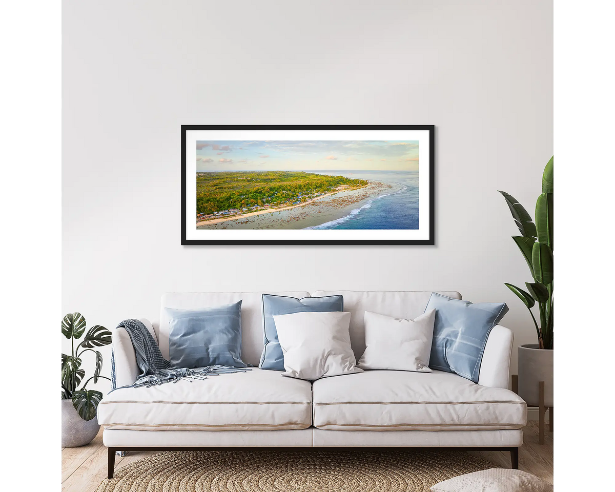 Anetan Awakes. Framed wall art print of Anetan Nauru at sunrise, with a black frame, hung above a couch. 