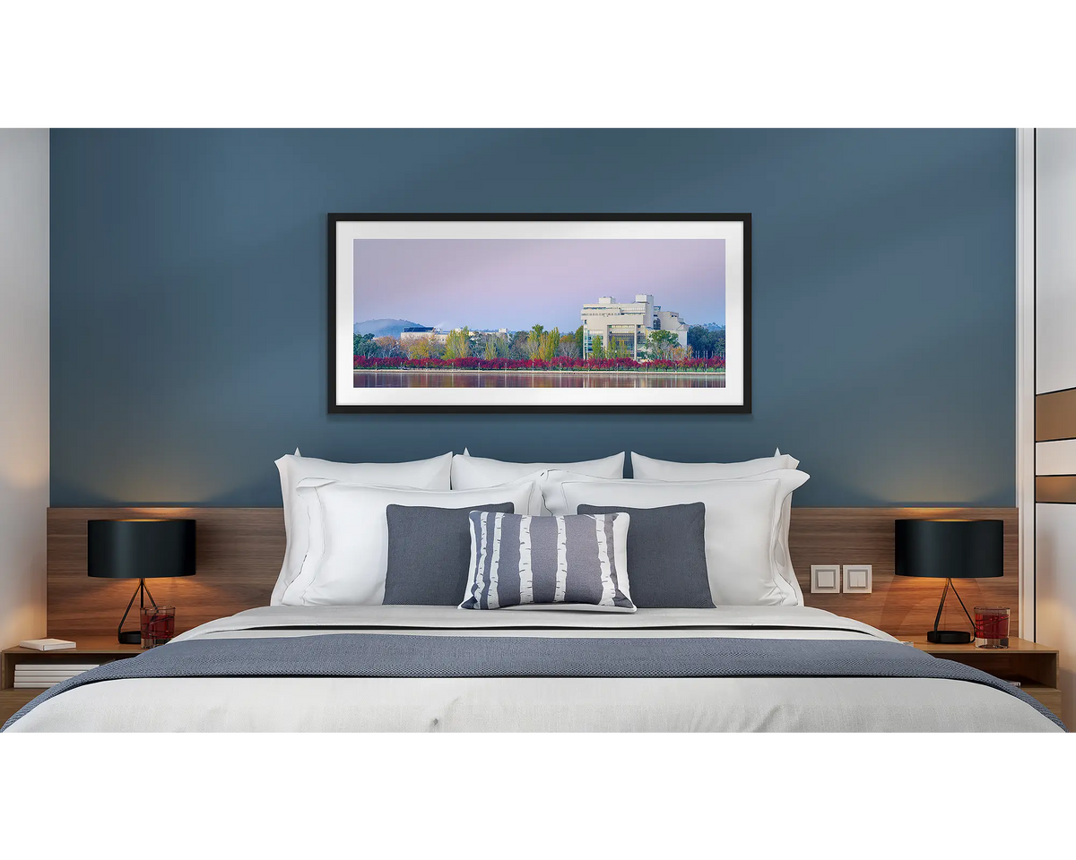 Roll of Honour. Wall art print of the Australian War Memorial at night, framed with a black frame and hung above a bed in a hotel room. 
