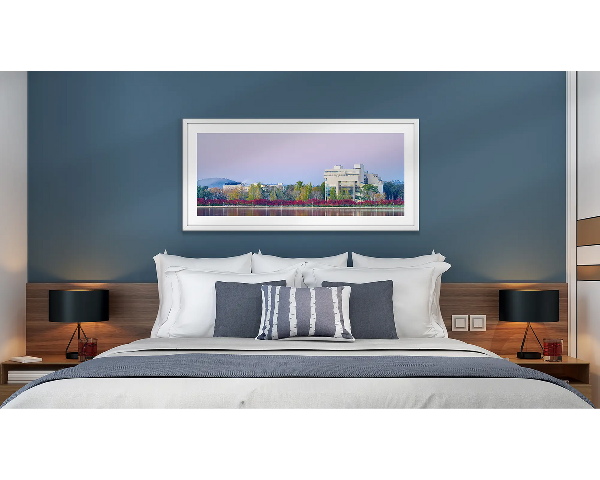 Art and Law. Wall art print of the High Court and National Gallery, framed with a white frame and hung above a bed in a hotel room. 