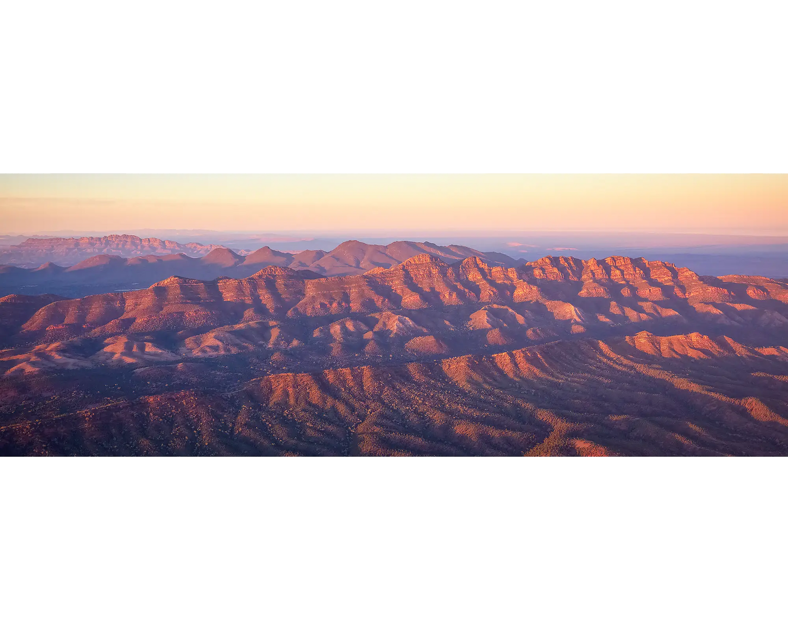 Sunset over Razorback Ridge in the Flinders Ranges with warm hues on the horizon.