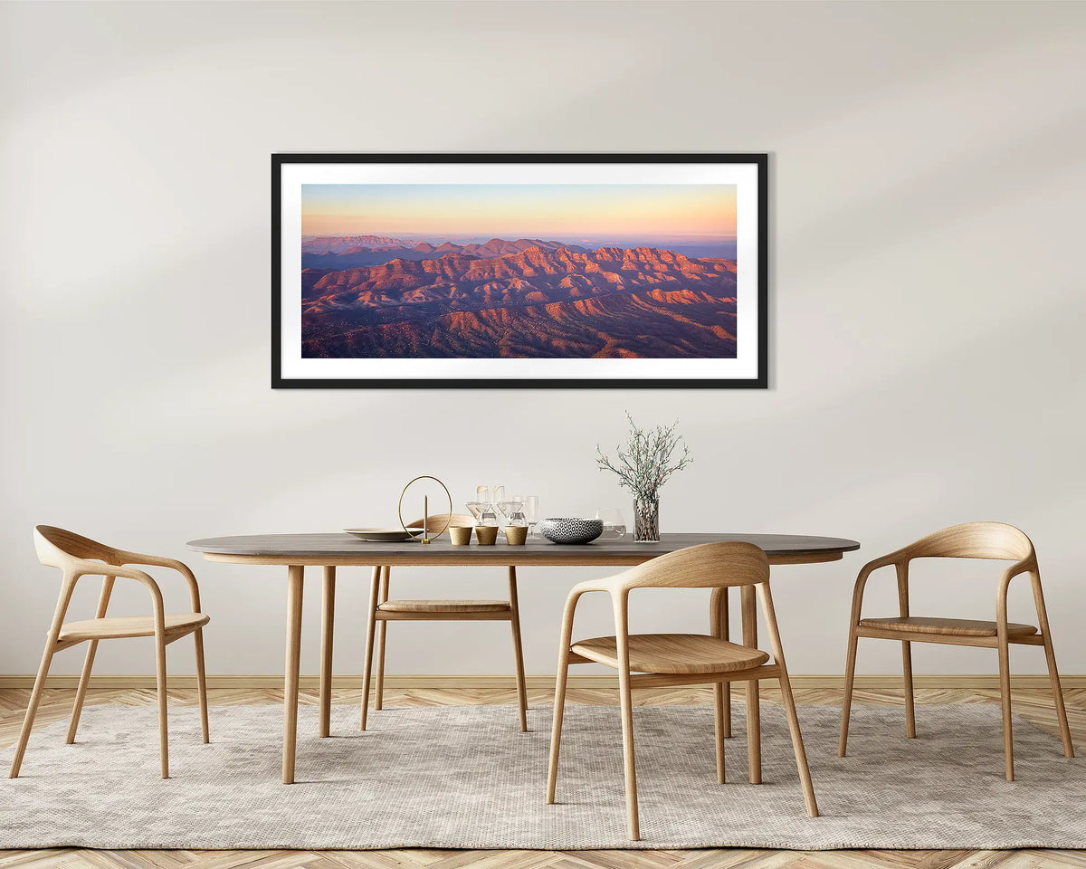 Art of the Ages. Wall art print with a black frame, of a sunrise over Razorback Ridge, Flinders Ranges, hung in a dining room. 