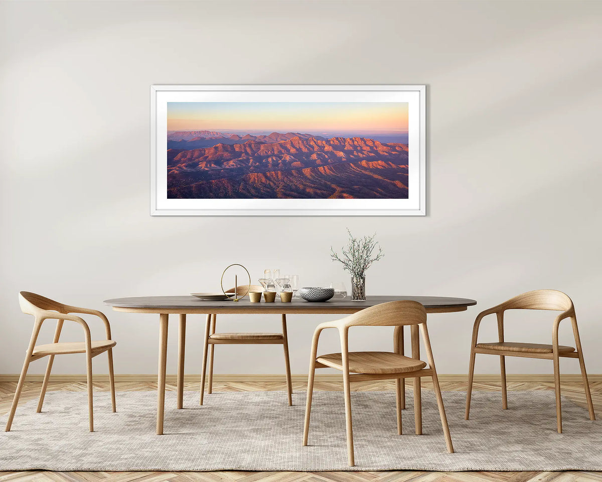 Art of the Ages. Wall art print with a white frame, of a sunrise over Razorback Ridge, Flinders Ranges, hung in a dining room. 