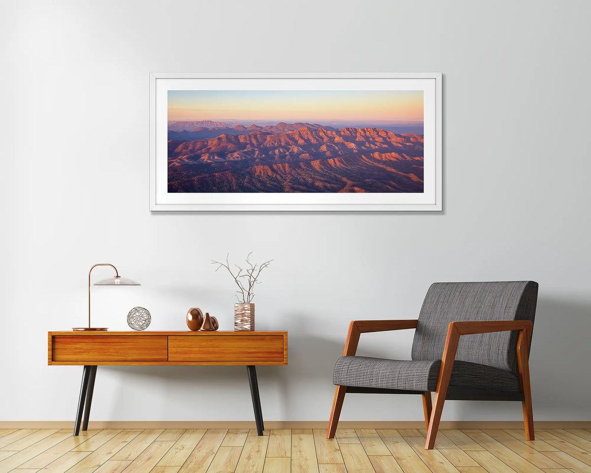 Art of the Ages. Wall art print with a white frame, of a sunrise over Razorback Ridge, Flinders Ranges, hung in a home entrance. 
