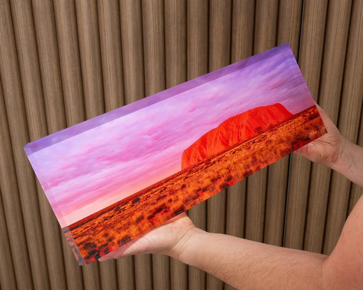 Australian Icon. Acrylic block of Uluru at sunset, Northern Territory, held in hands.