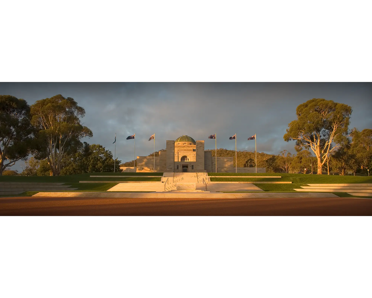Australian War Memorial surrounded by gum trees at sunset.