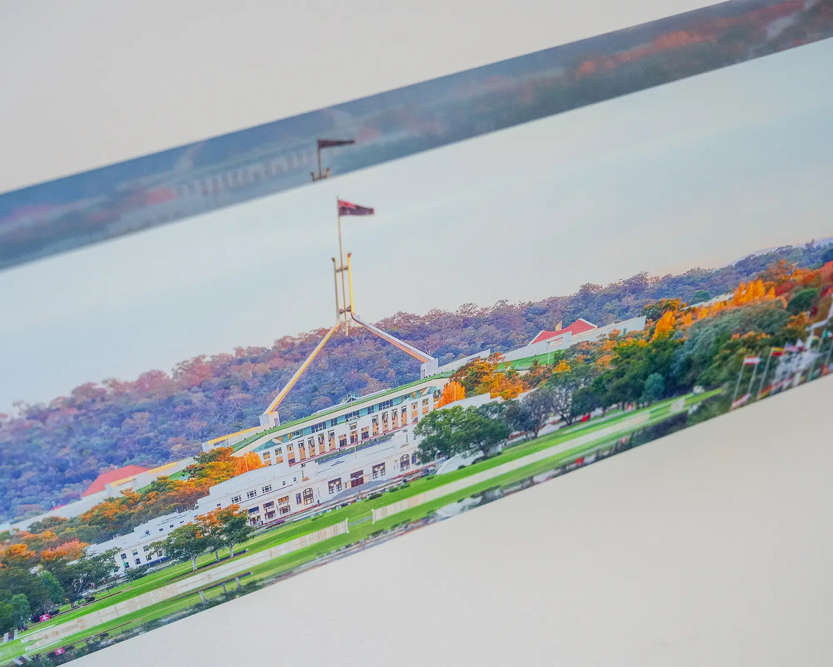 Autumn Bubble. Acrylic block of colourful autumn trees in front of Old and New Parliament House, close-up image.