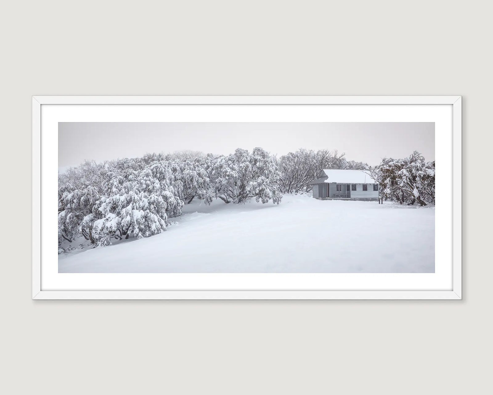 Framed wall art print of Federation Hut covered in fresh snow and surrounded by snow gums covered in ice. 