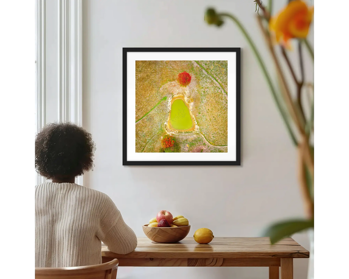 Ball Game. Farm dam, abstract photographic wall art print, with a black frame, hung on a kitchen wall with a women admiring. 