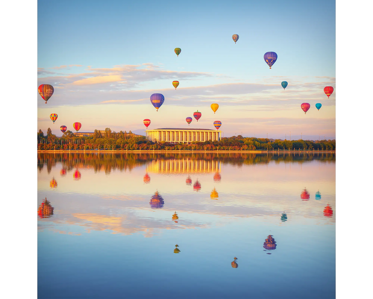 Hot air balloons floating over the National Library of Australia and Lake Burley Griffin, Canberra.