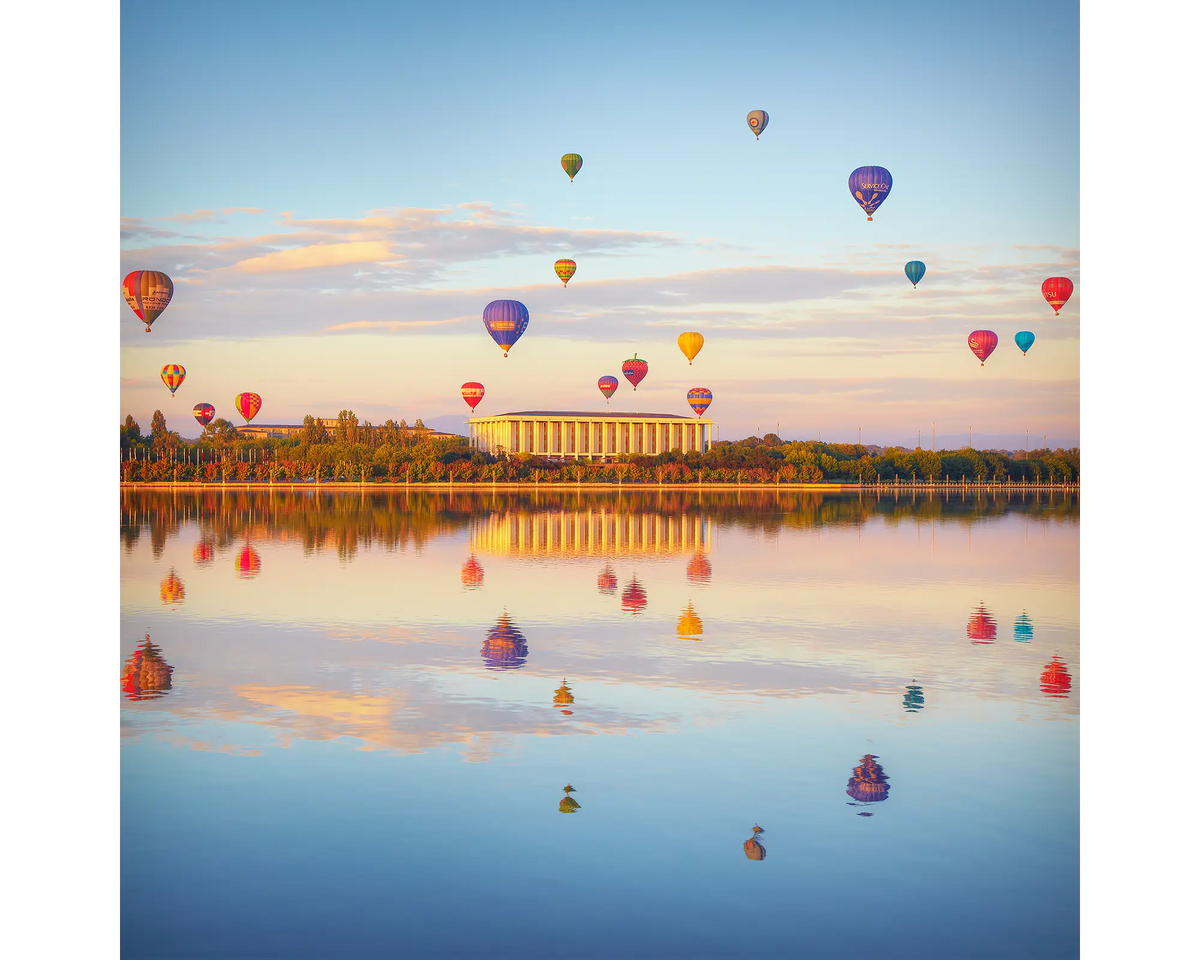 Balloon Spectacular. Hot air balloons over the National Library and Lake Burley Griffin at sunrise, Canberra.