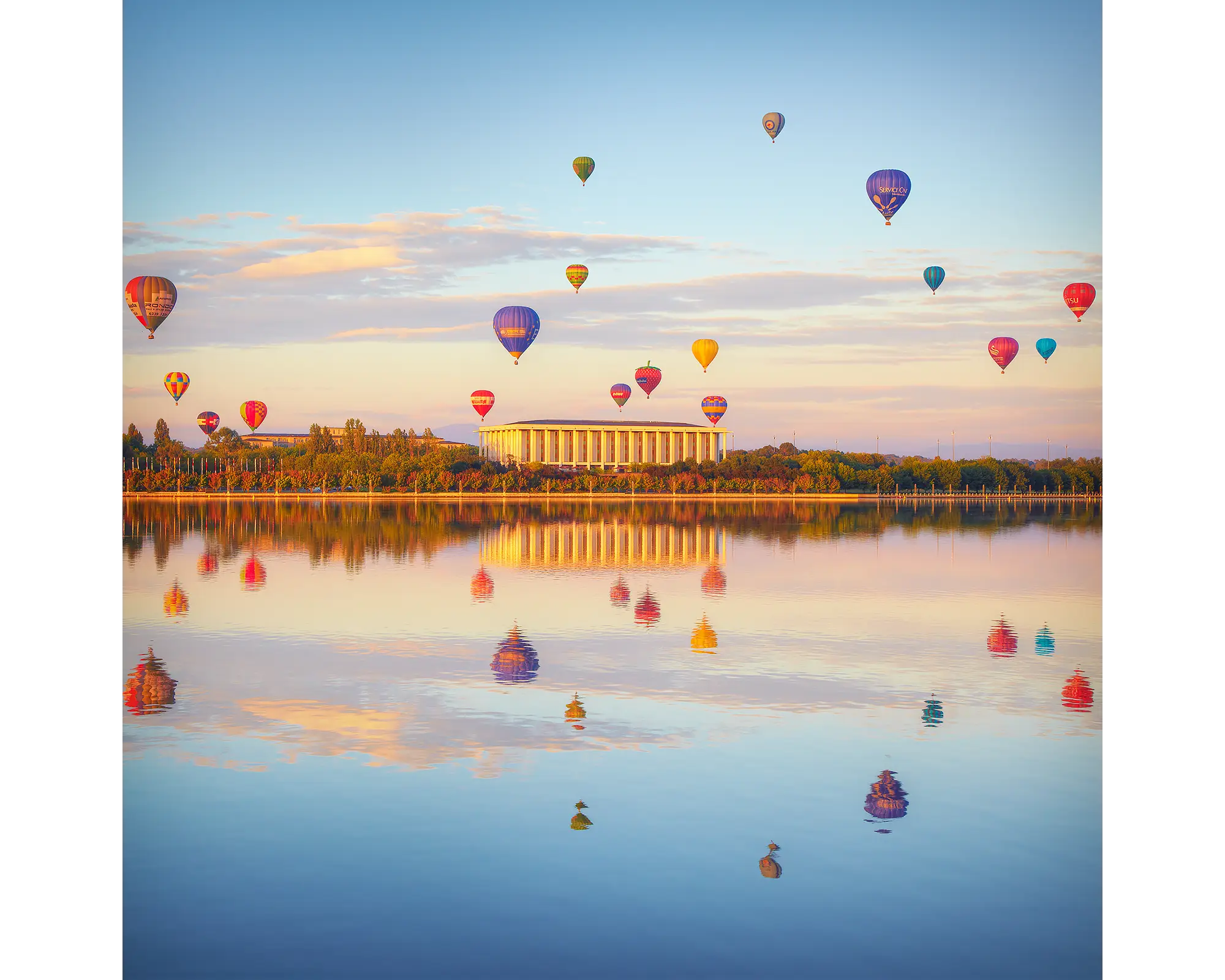 Balloon Spectacular. Hot air balloons over the National Library and Lake Burley Griffin at sunrise, Canberra.