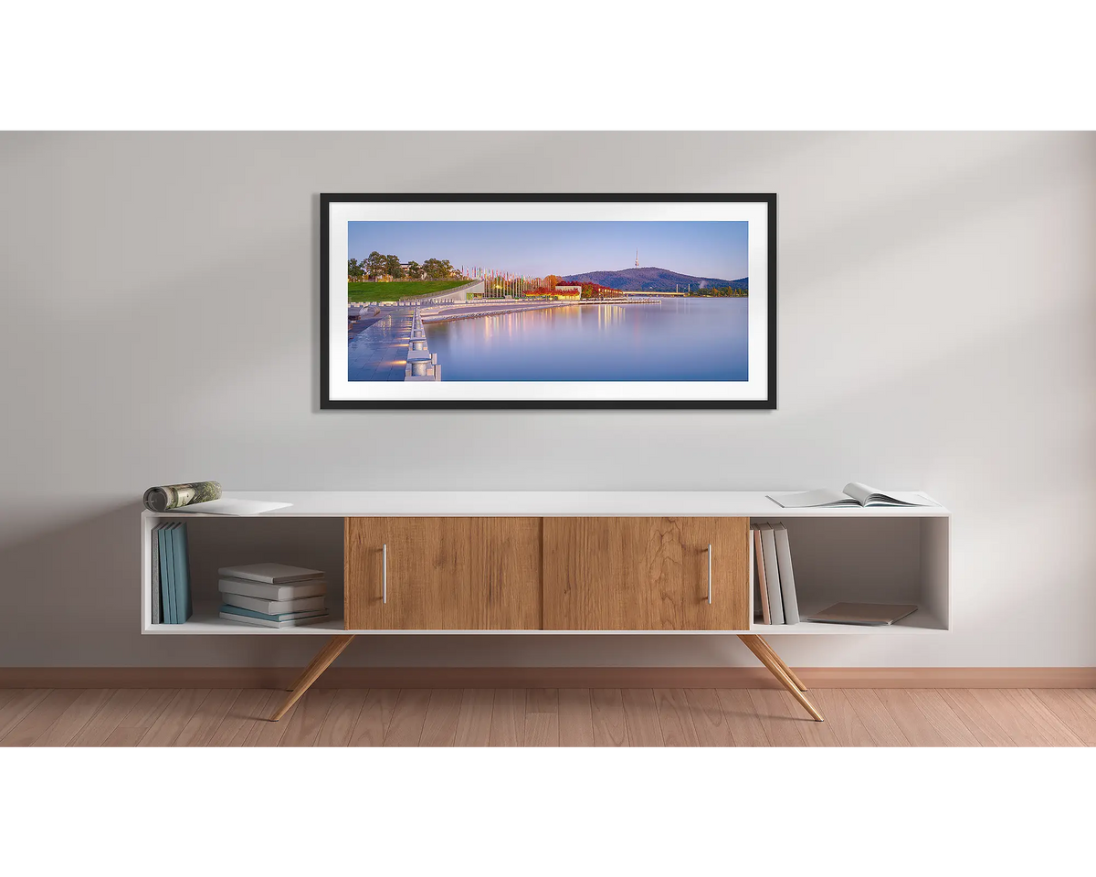 Before the Rush. Canberra sunrise wall art print with a black frame above a couch. 
