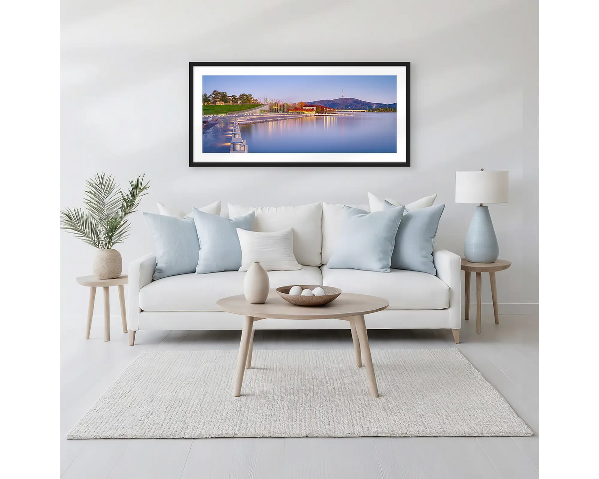 Before the Rush. Canberra sunrise wall art print with a black frame hung above a white couch. 