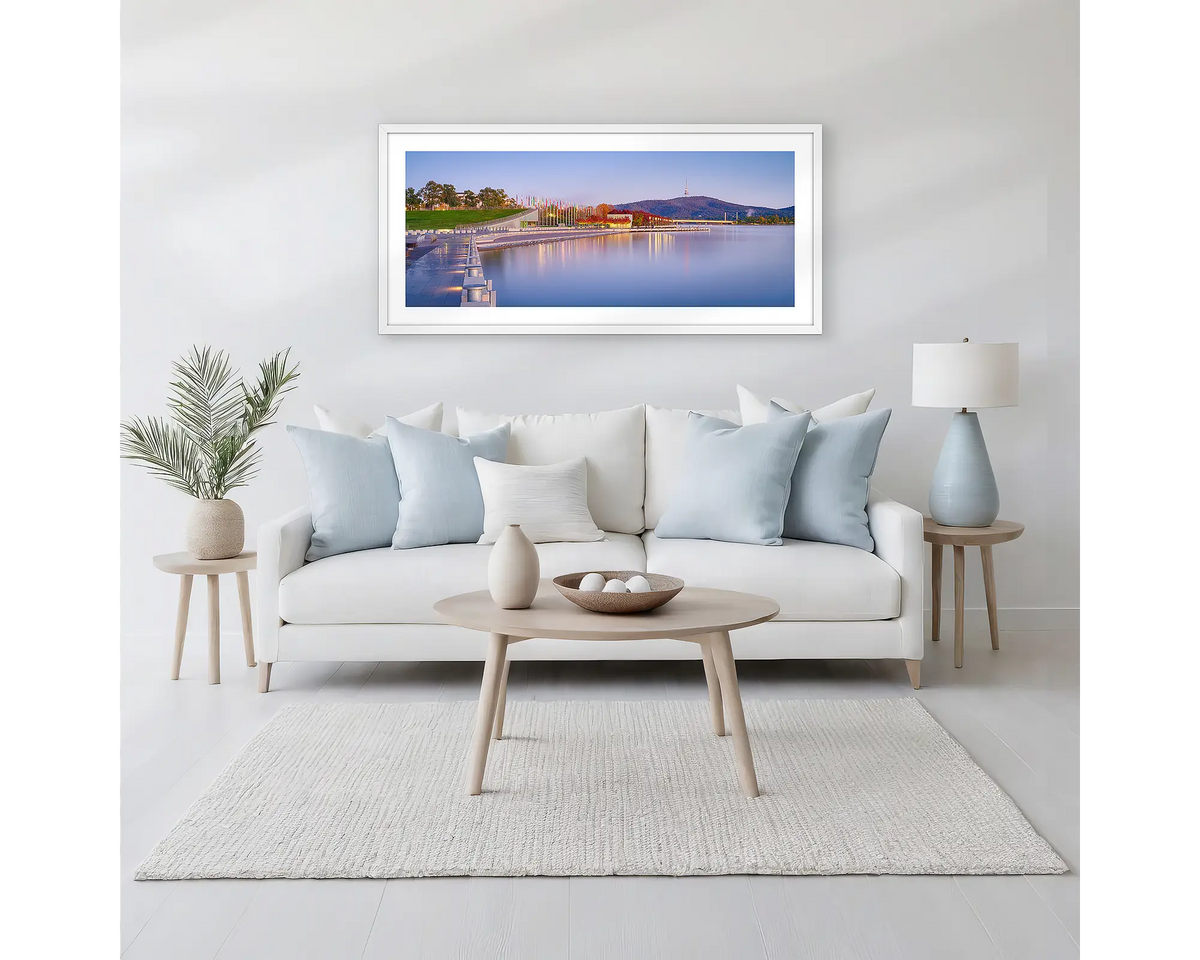 Before the Rush. Canberra sunrise wall art print with a white frame hung above a white couch. 
