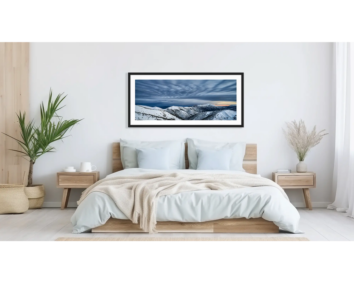 Before the Storm. Wall art print of cloud formations over Mount Feathertop, framed in a black frame, and hung above a bed. 