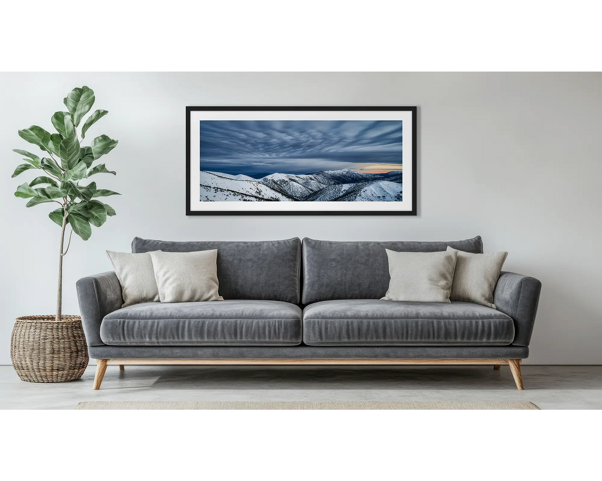 Before the Storm. Wall art print of cloud formations over Mount Feathertop, framed in a black frame, and hung above a couch. 
