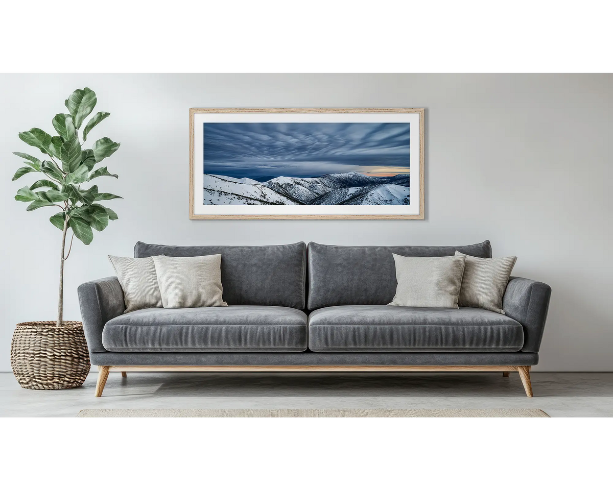 Before the Storm. Wall art print of cloud formations over Mount Feathertop, framed in a Tasmanian Oak frame, and hung above a couch. 