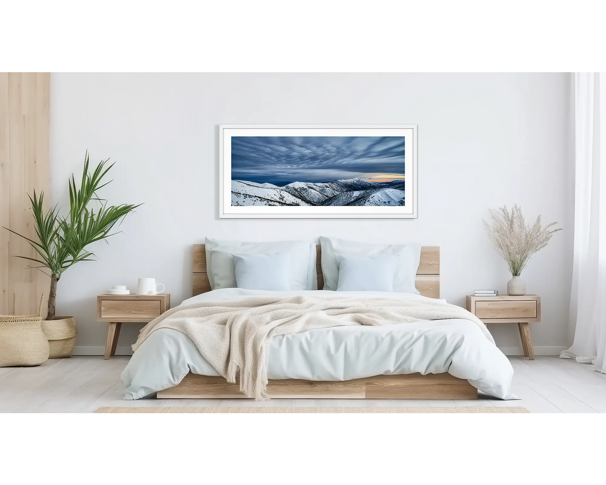 Before the Storm. Wall art print of cloud formations over Mount Feathertop, framed in a white frame, and hung above a bed. 