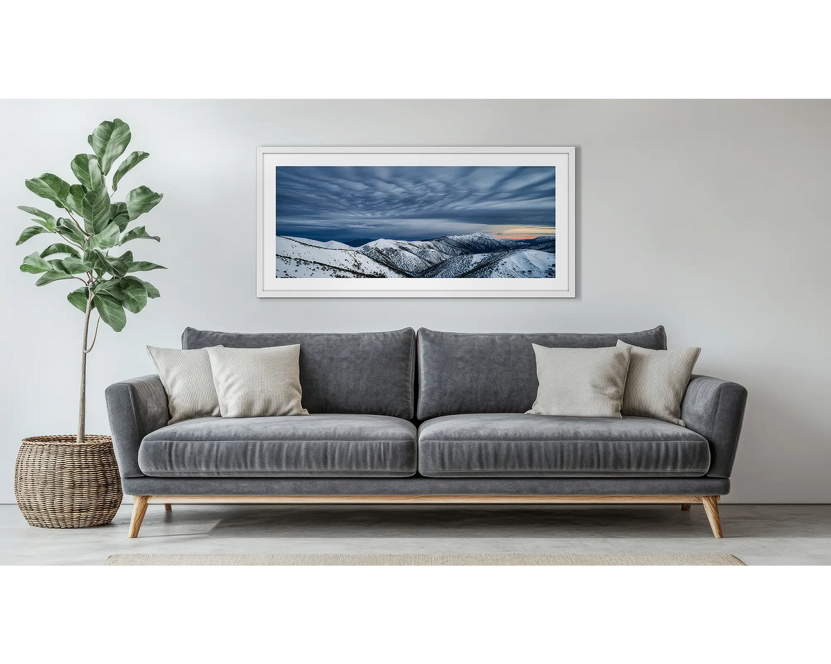 Before the Storm. Wall art print of cloud formations over Mount Feathertop, framed in a white frame, and hung above a couch. 