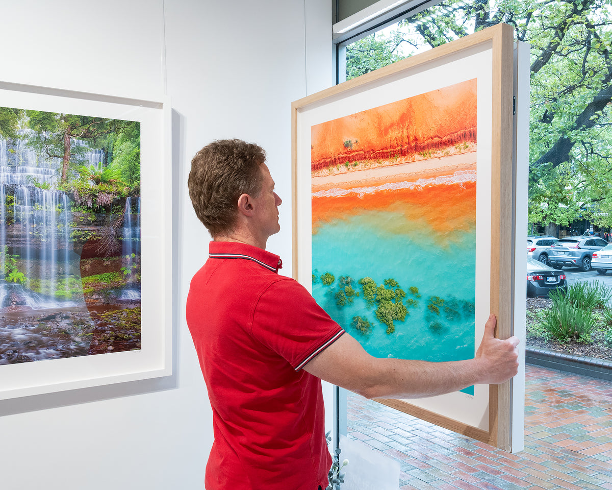 Blend. Abstract aerial artwork The Kimberley, Western Australia, with timber frame, being hung in gallery window.