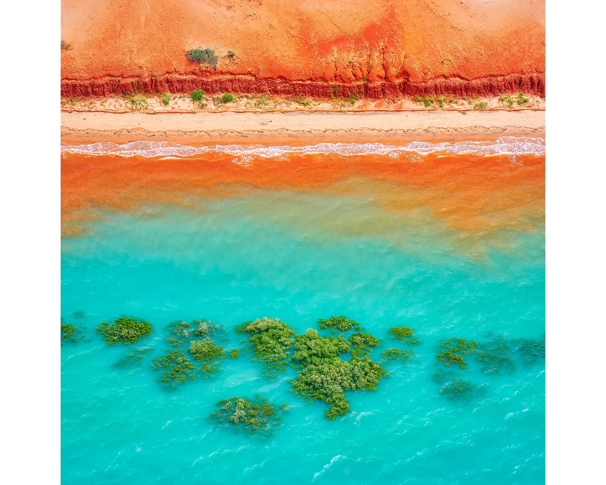 Aerial view of the red pindan sands and turquoise waters of Broome Beach in the Kimberley, Western Australia.