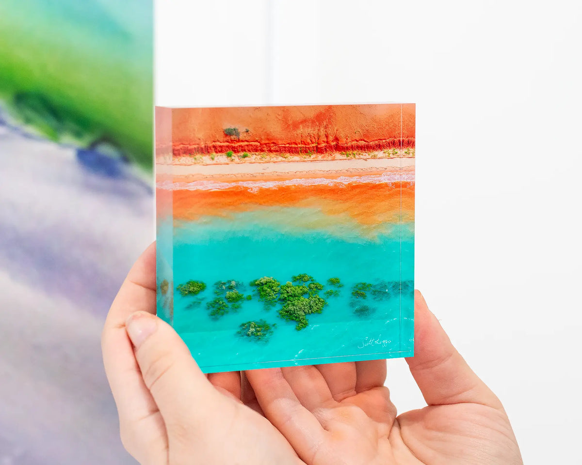 Blend - Coastal artwork - 10cm acrylic block being held in hand.