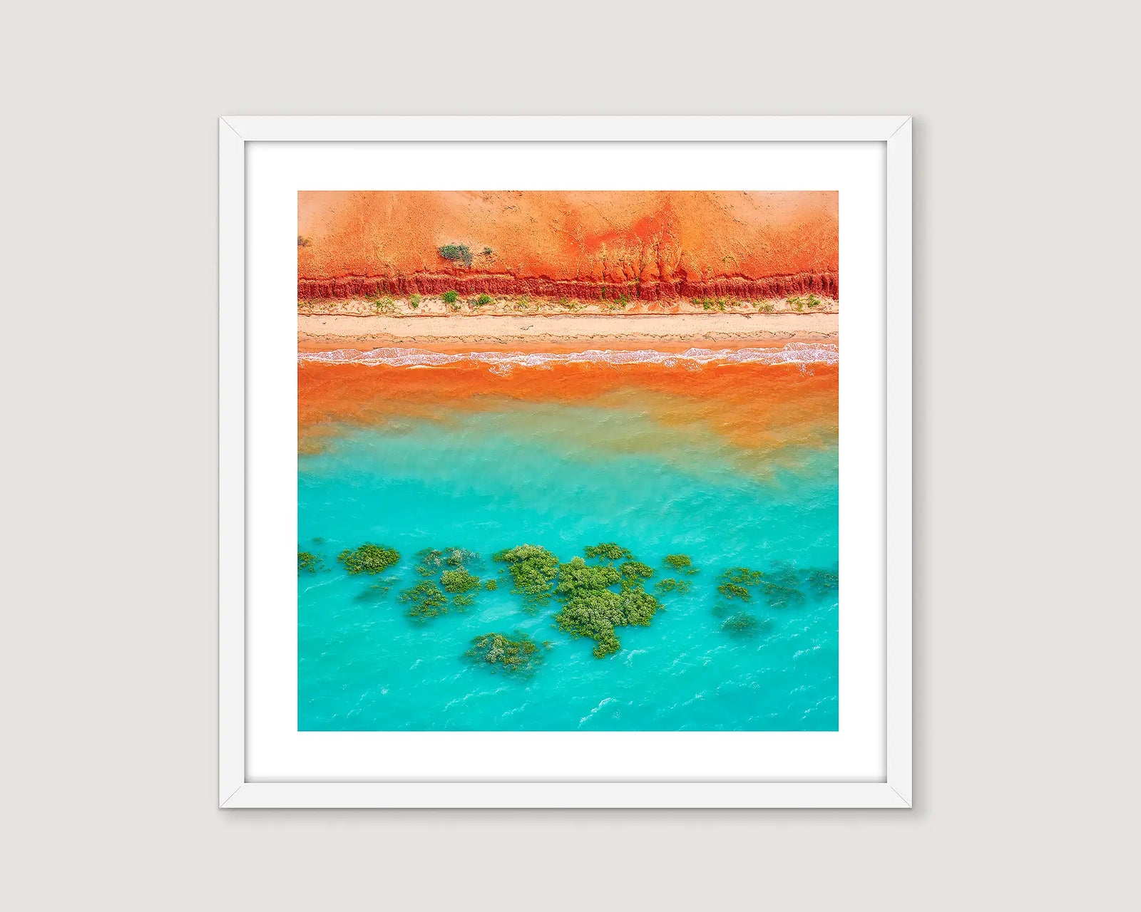 Framed photographic wall art print of an aerial view of red earth meeting the ocean near Broome. 