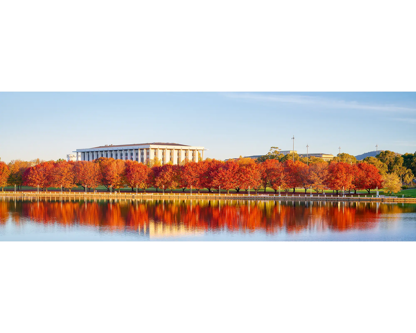 Bookend. Red autumn trees reflecting in Lake Burley Griffin beside the-National Llibrary Of Australia.