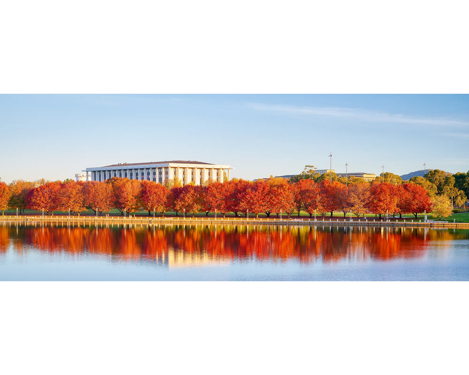 Bookend. Red trees reflecting in Lake Burley Griffin beside the National Library of Australia.