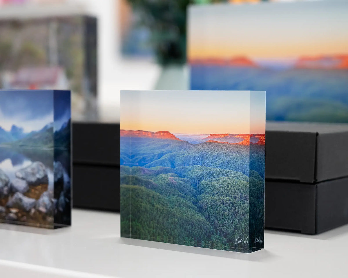 Breaking Dawn. Acrylic block of sun rising over Blue Mountains National Park, displayed in gallery with more Australian acrylic blocks.