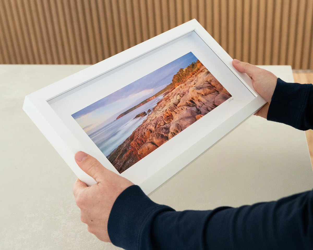 Breaking Through. South Coast small framed print with white frame being hand held.