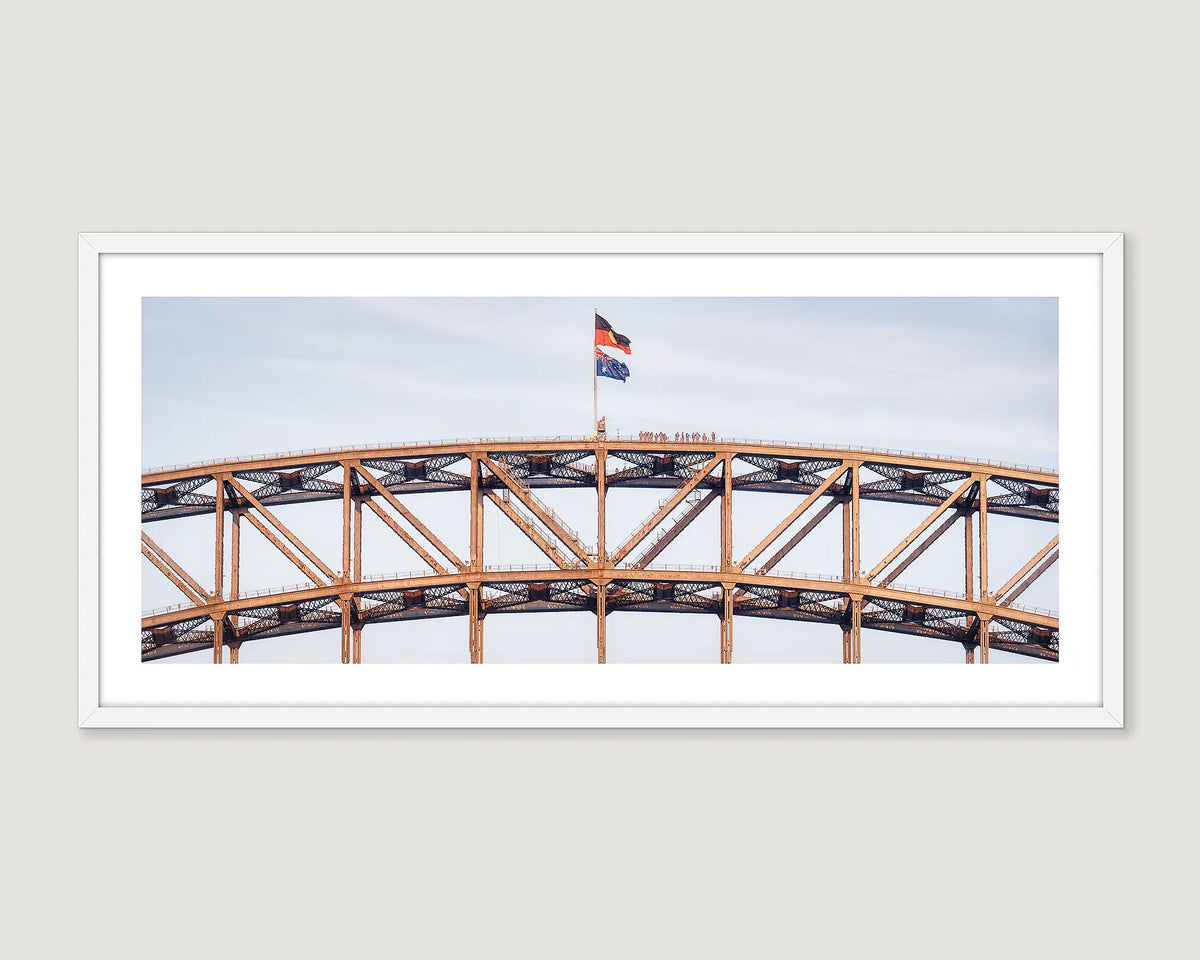Framed photograph of climbers on top of Sydney Harbour Bridge. 