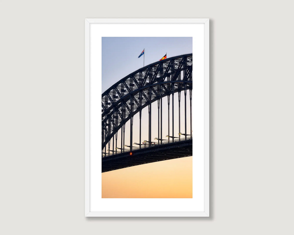 Framed artwork of Sydney Harbour Bridge against a sunset sky.