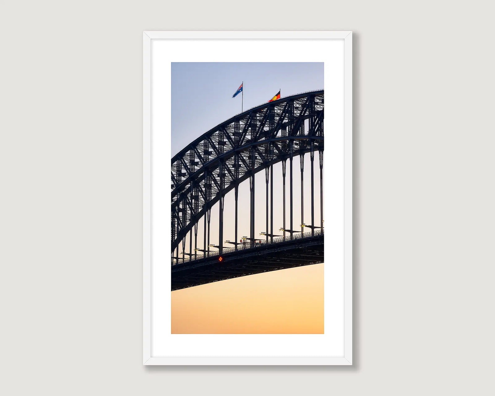 Framed artwork of Sydney Harbour Bridge against a sunset sky.