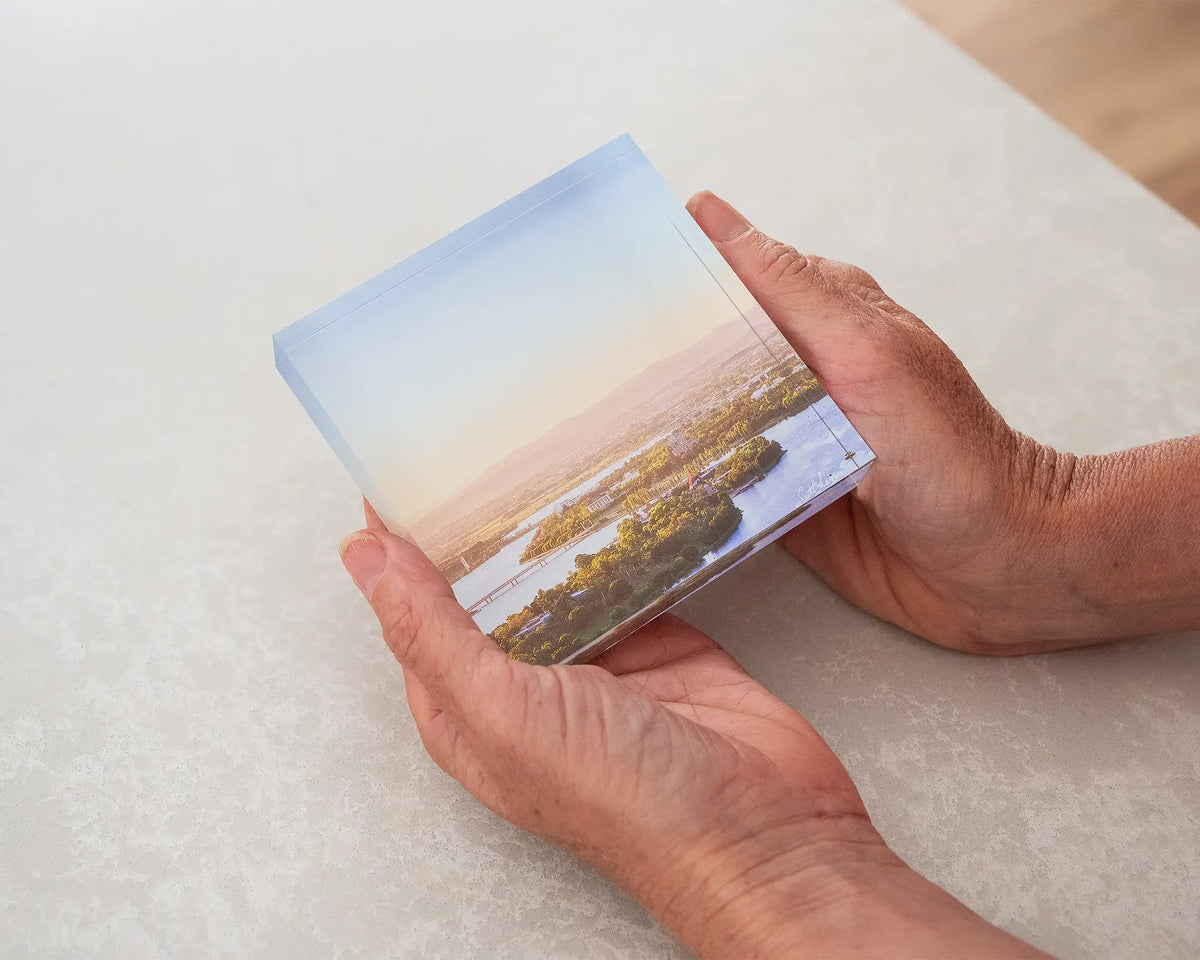 Brighter Days. 10cm acrylic block of Autumn sunrise over Canberra, held in hands.