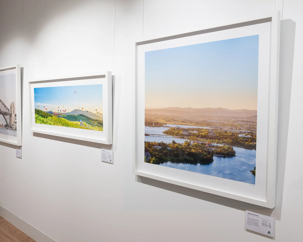 Brighter Days. Bright autumn sunrise over Canberra with white frame, hung in gallery with Canberra artwork.