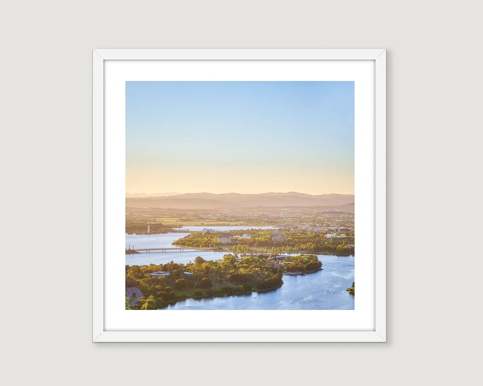 Framed photograph from an aerial perspective of Lake Burley Griffin and Canberra surrounds with a view to the Brindabella Ranges. 