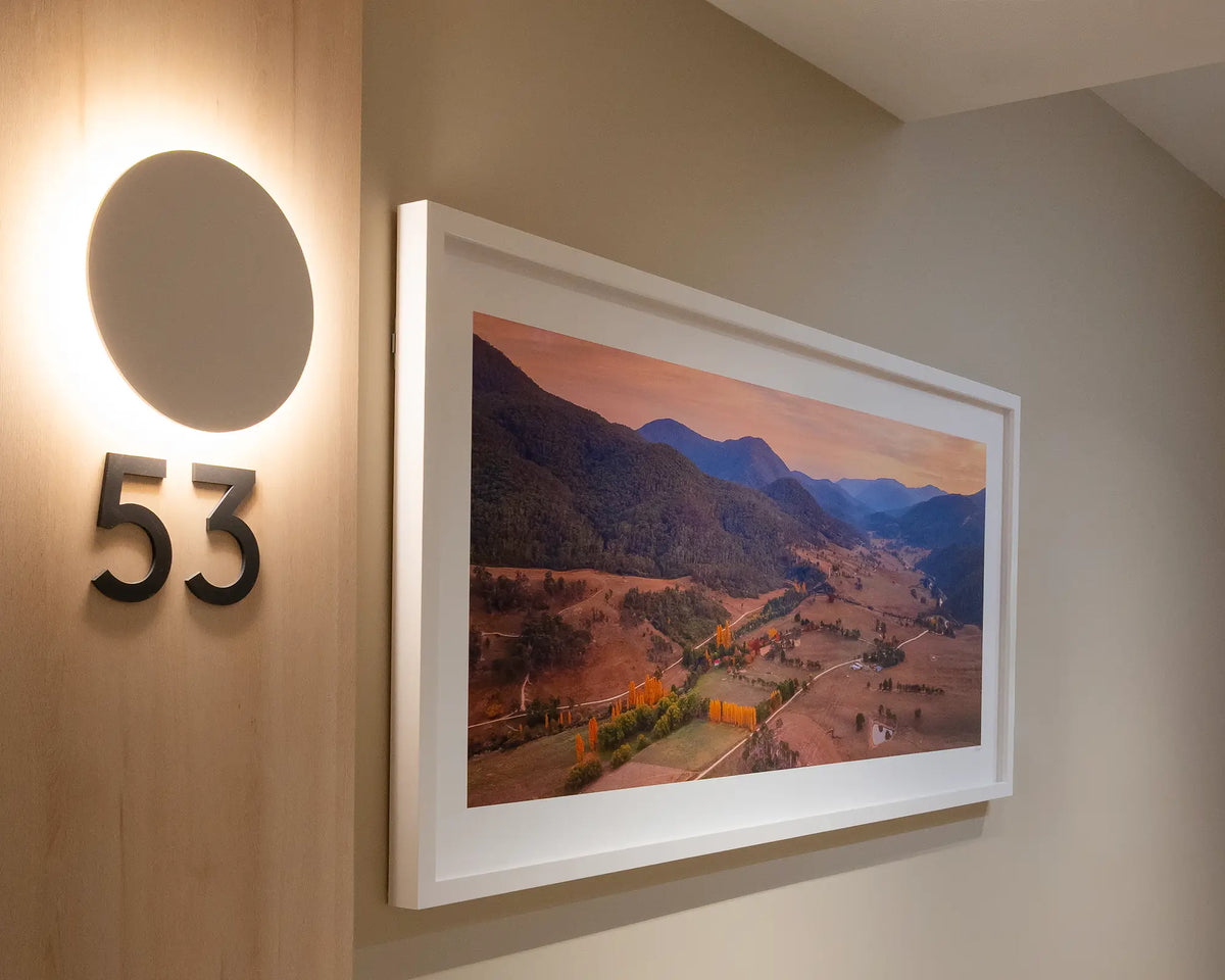 Brindabella Rise. Sunrise over Brindabella Valley, New South Wales, with white frame on neutral wall in apartment building.