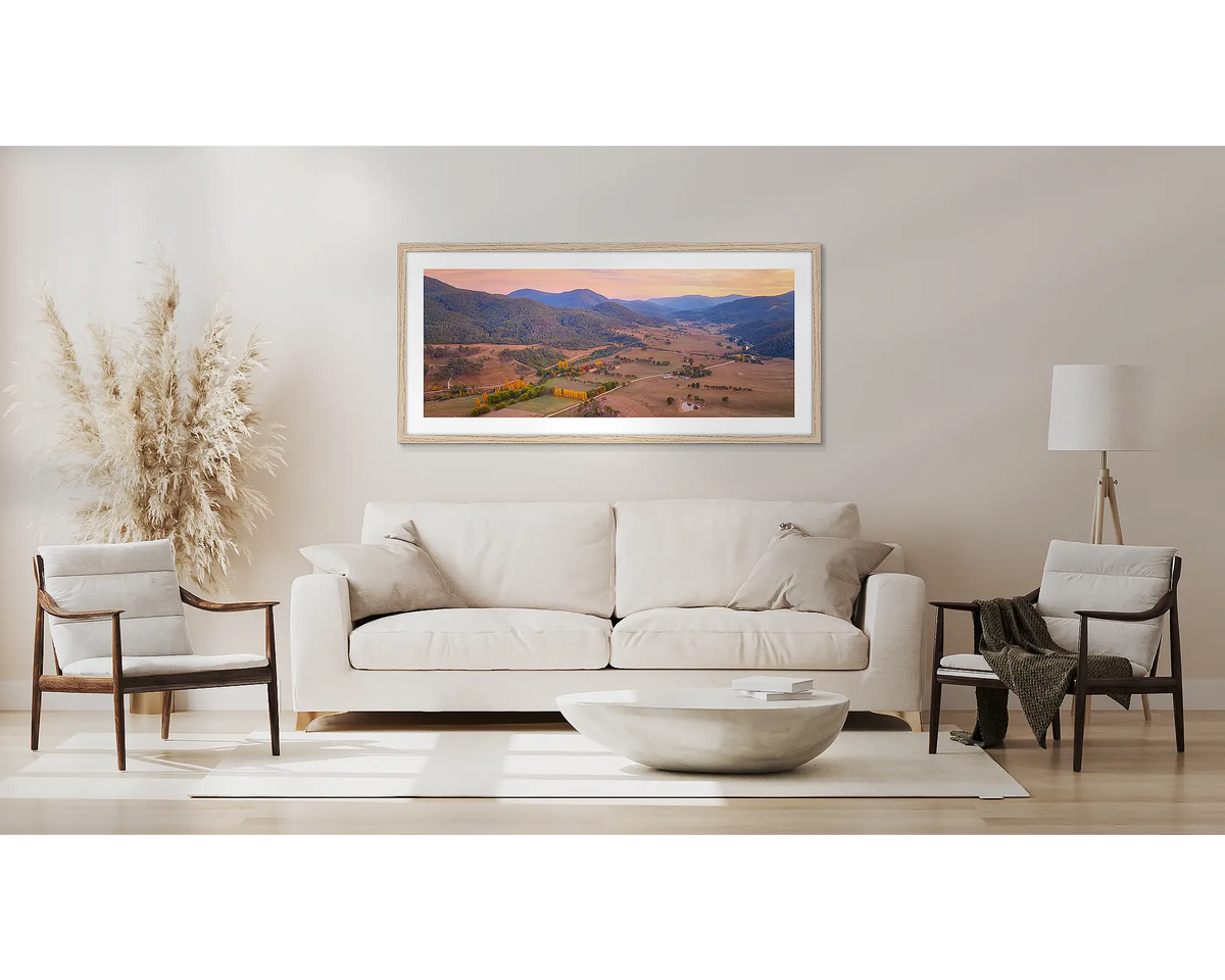Brindabella Rise. Wall art print with timber frame of a sunrise over Brindabella Valley hung above a couch.