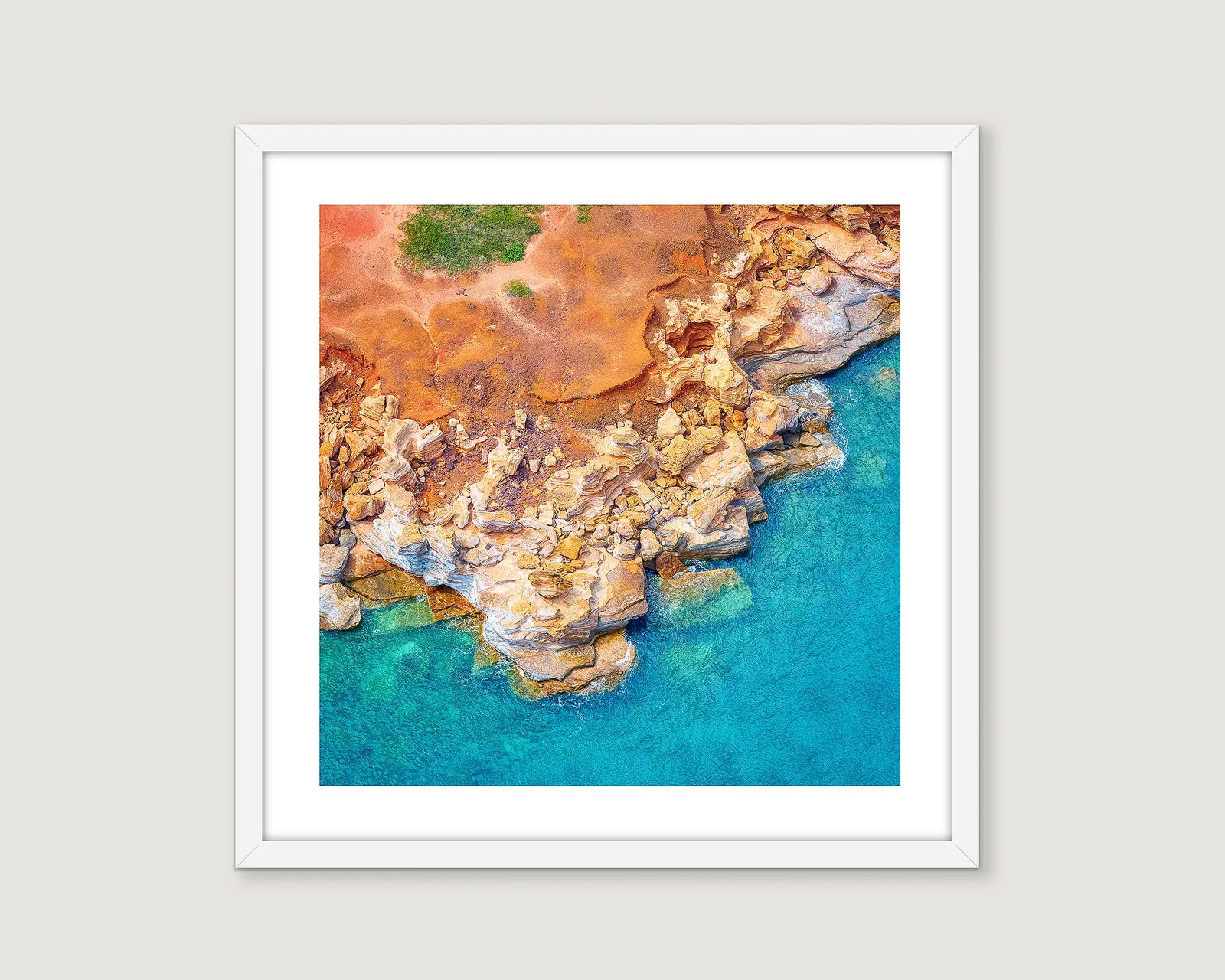 Framed Photographic aerial image of red rocks meeting the ocean at Gantheaume Point.